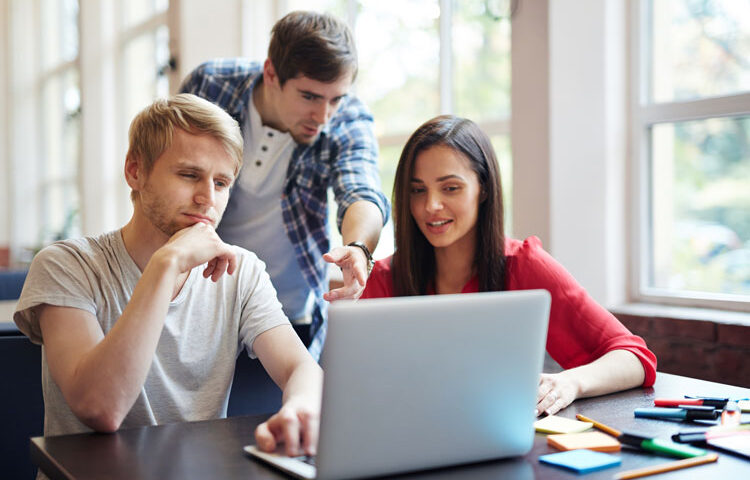 Foto de tres chicos mirando un ordenador